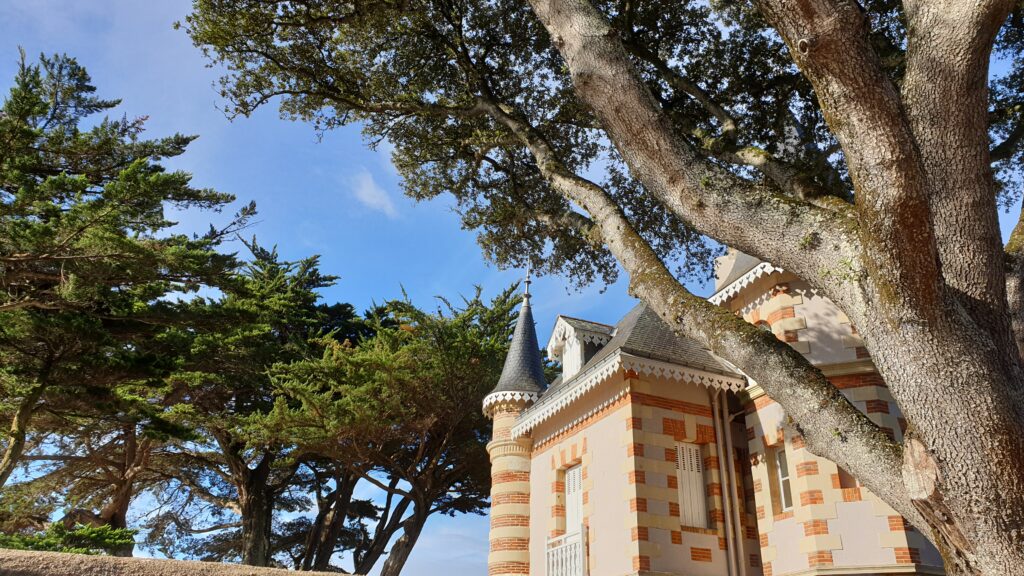 Erwartungen zum Wochenende. Ein Haus an der Bretagne mit kleinen Türmchen unter Bäumen