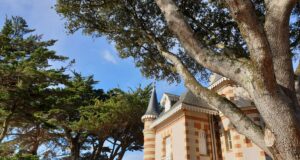 expectations weekend reflections: a coast house with turrets under trees