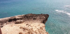 A cliff as a starting point (a blackened cliff above turquoise sea.